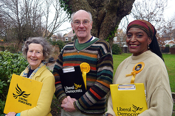 Philippa Gray, Michael Lind and Annie Martin standing together holding Lib Dem clipboards